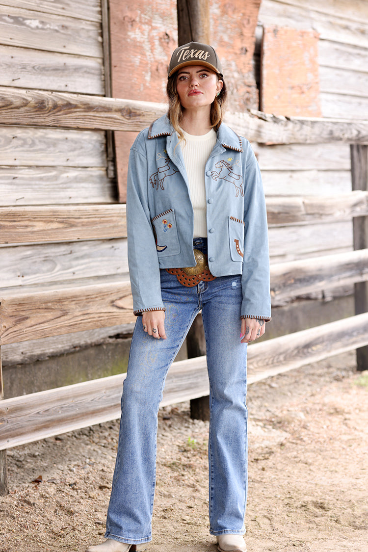 Woman wearing a light blue suede embroidered  jacket with patches, jeans, and a  Texas Embroidered Trucker Hat - Gold/Olive-FleaStyle