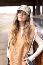 Woman wearing a Light Brown Embroidered Fringe Cape, white long-sleeve shirt, and embroidered Howdy-Darlin_Camo-Trucker-Hat-Beige-FleaStyle