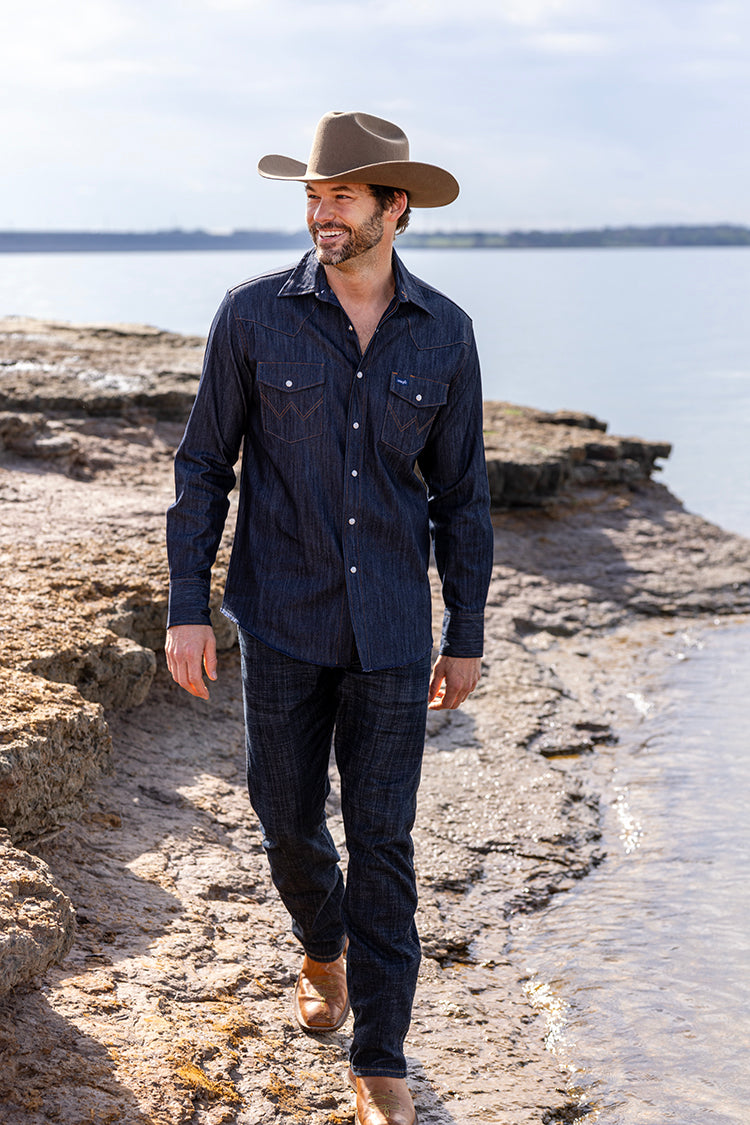 Man in a Rider Wool Cowboy Hat - Brown and dark shirt walking along a rocky shoreline-FleaStyle