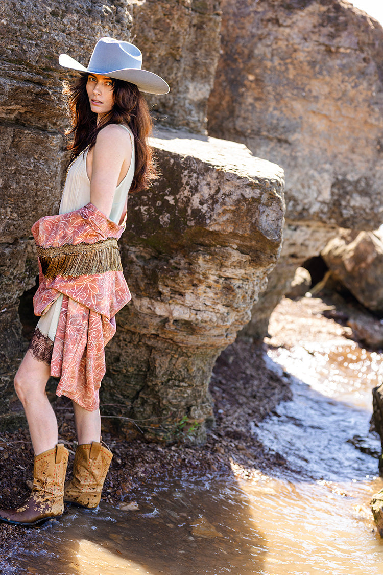 Woman in a Tex-Cowboy-Wool-Hat-DustyBlue-Fleastyle, vintage kimono, and boots standing on a rocky beach-Fleastyle