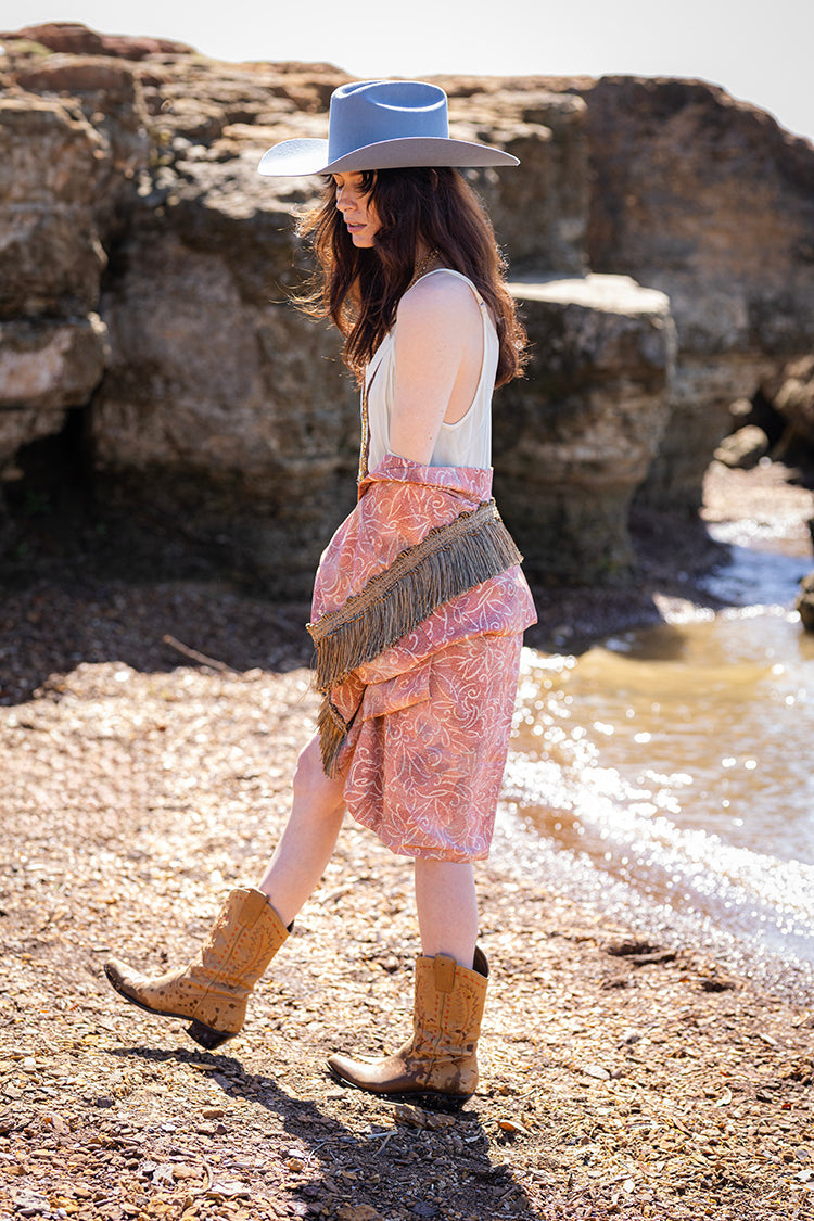 Woman in a Tex-Cowboy-Wool-Hat-DustyBlue-Fleastyle, vintage kimono, and boots standing on a rocky beach-Fleastyle