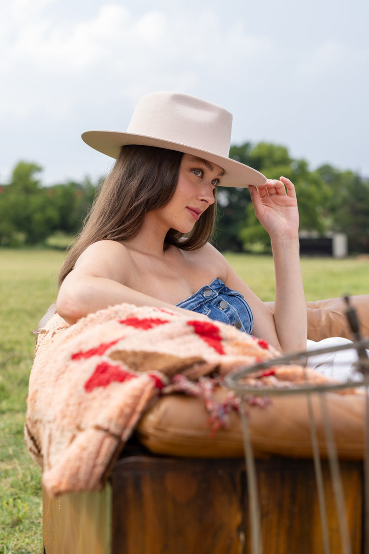Woman sitting outdoors in a field wearing Lenny Wool Short-Brim Hat - Blush-Fleastyle