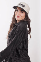 Woman wearing a black fringe jacket and black  'Texas' trucker hat-FleaStyle