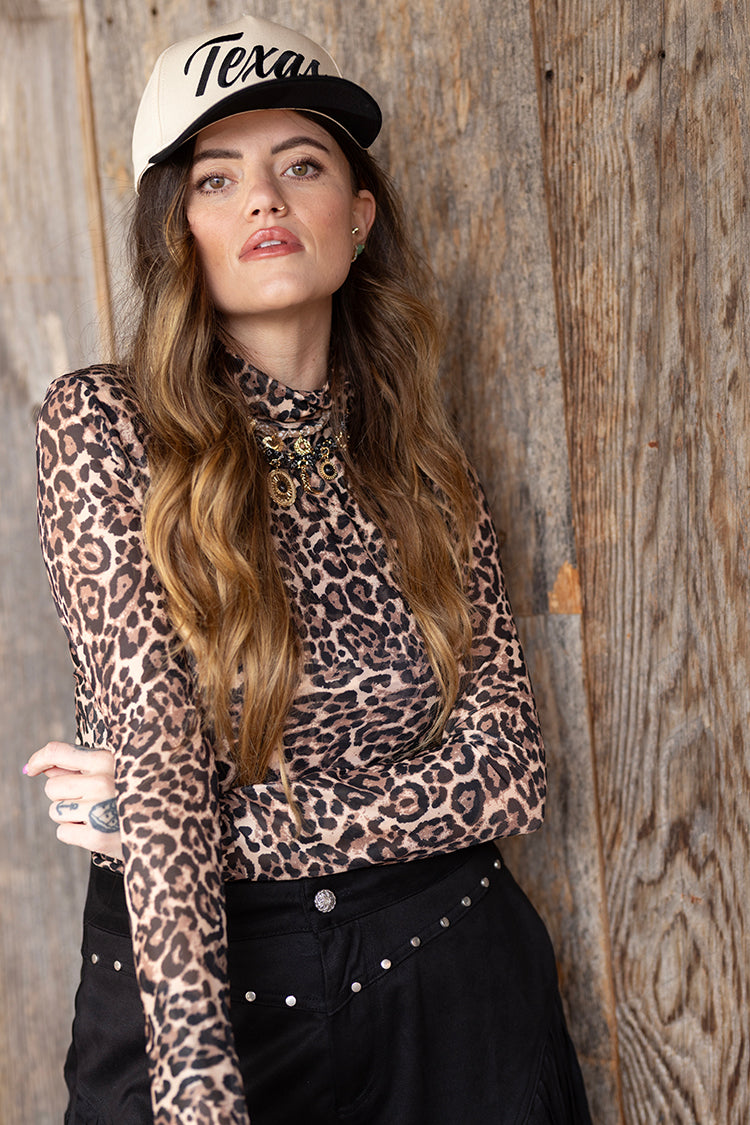 Woman wearing a leopard print mesh top and black  'Texas' embroidered trucker hat-FleaStyle